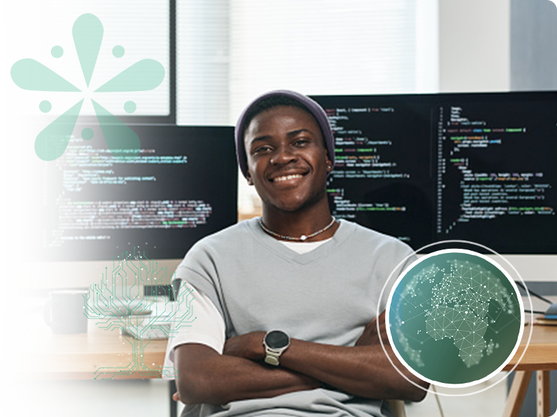 Developer sitting in front of monitors smiling